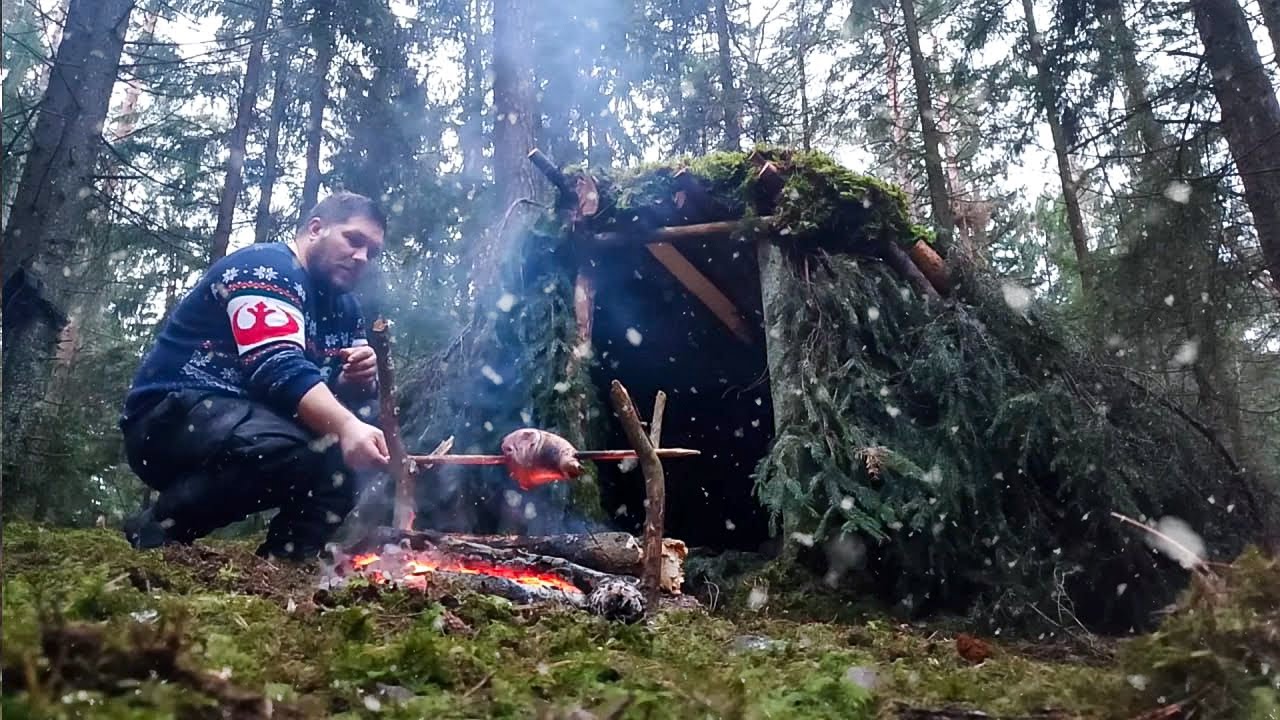 QUICK BUILDING OF A WARM SHELTER FROM RAIN. SURVIVAL IN THE WILDLIFE. NIGHT IN THE WINTER FOREST