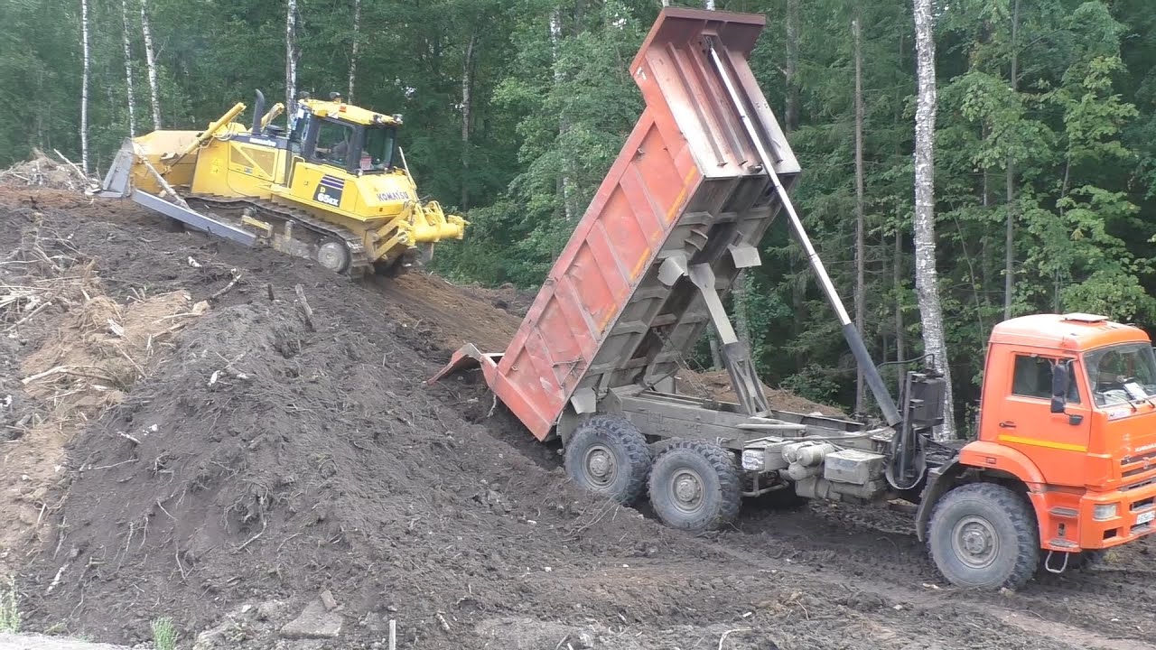 Бульдозер Komatsu D65EX-16 толкает грунт