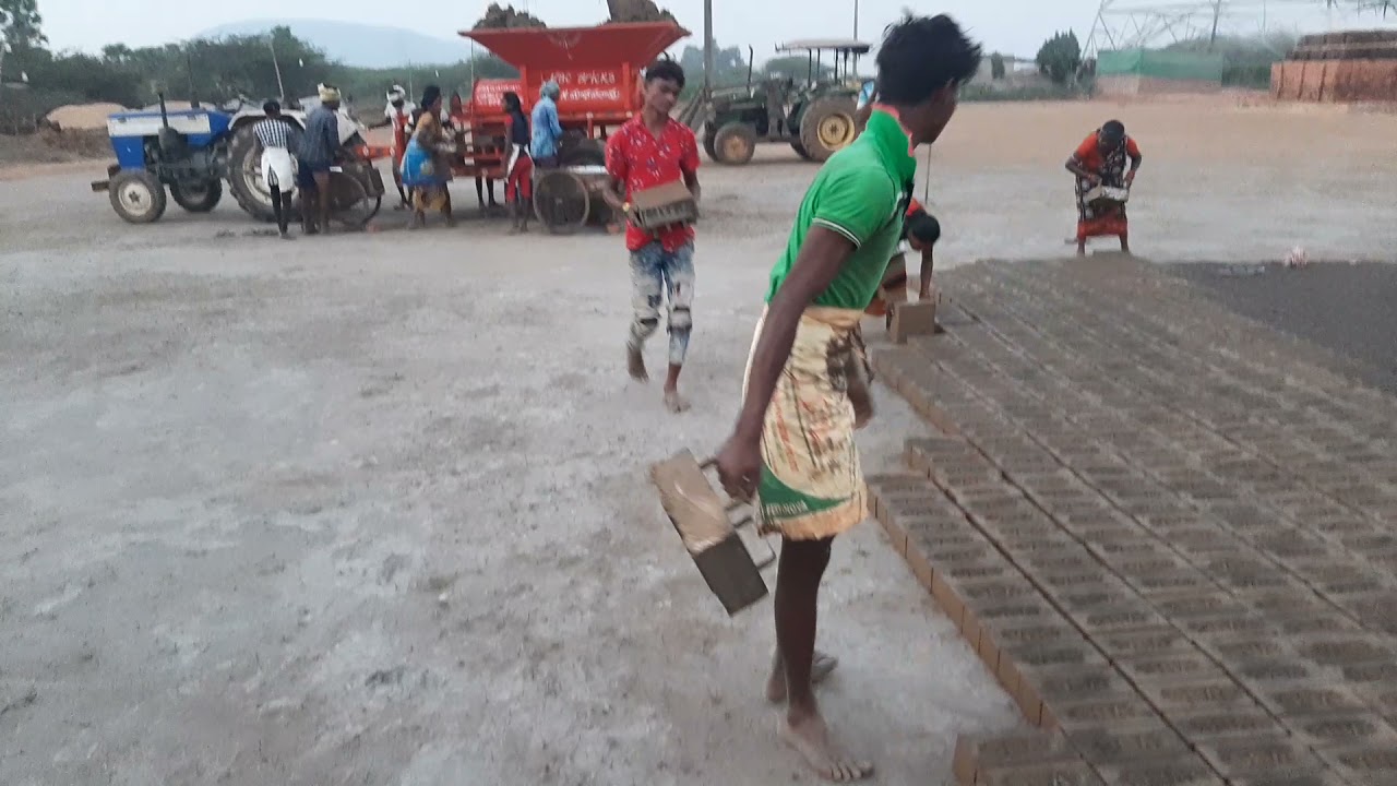 Tractor  attached red, clay bricks machine