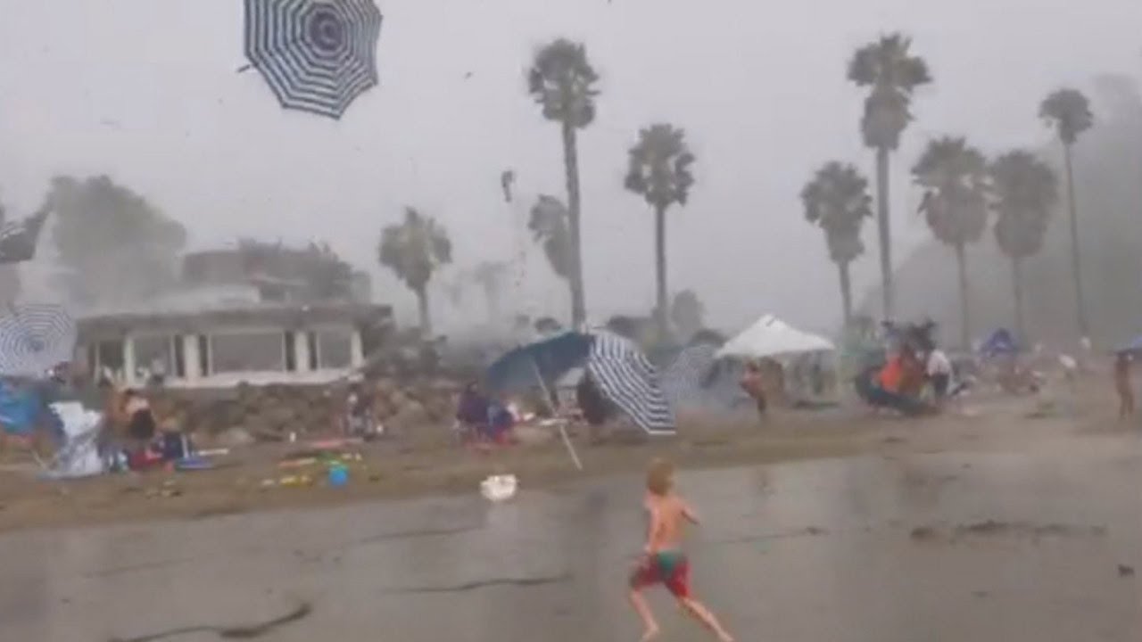 Parents Try to Protect Kids on Beach During Random Weather Occurrence