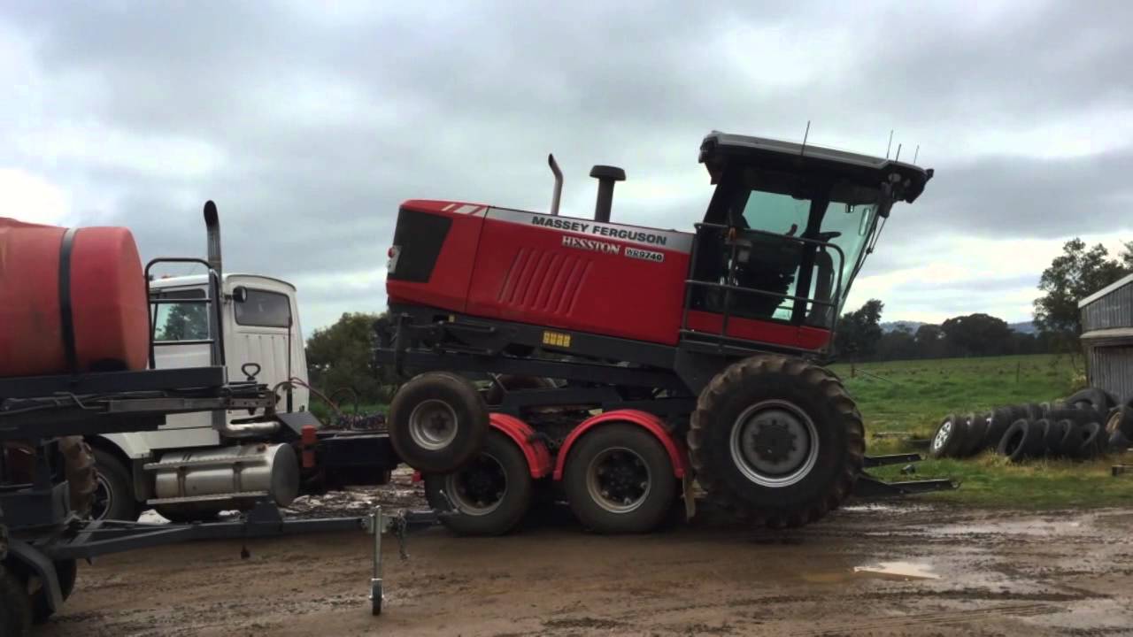 Loading Massey windrower and spray cart ready to transport