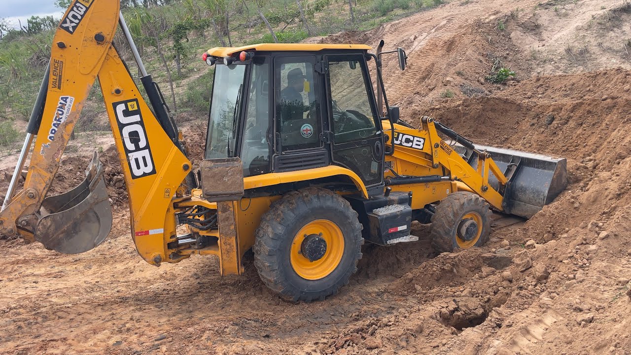 Retroescavadeira jcb aumentando a capacidade de um barreiro para ajuntar as águas da chuva