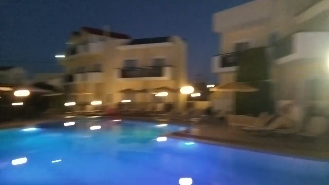 Hotel and swimmingpool area at the Sunset Suites hotel in Platanias in Crete at night time.