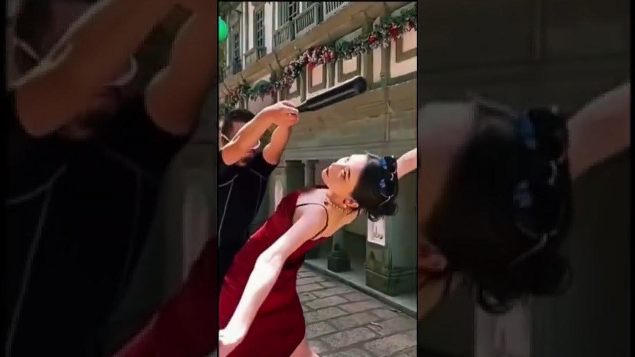 Woman in red dress dodging stick/bat