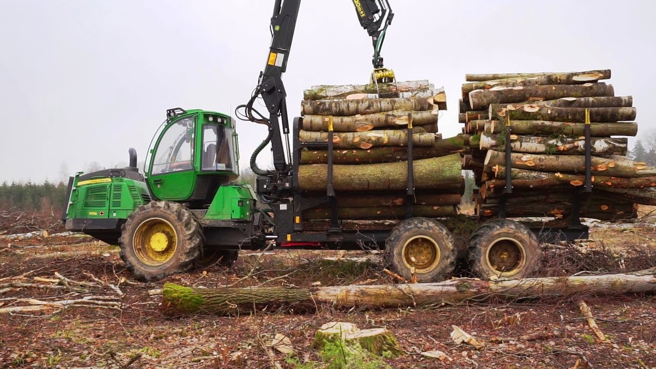 John Deere 1110E logging in winter forest, big load