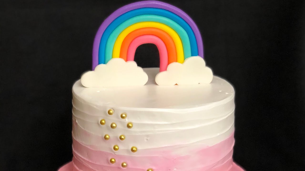 Pastel arcoiris con decoraciones en fondant.