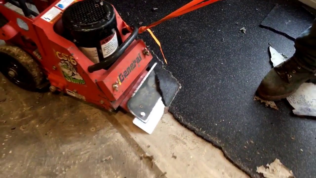 Removing rubber tiles from concrete floor.