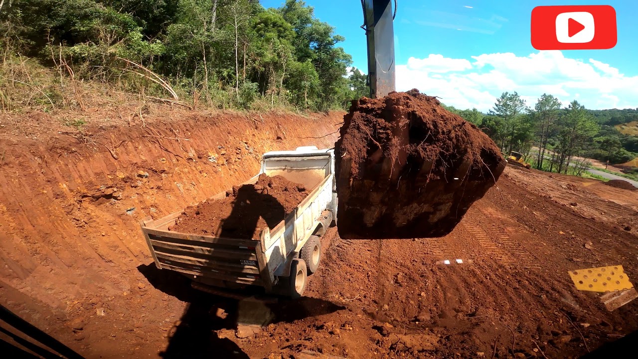 Continuando serviço de escavação, carregando caminhão caçamba com Escavadeira Hidráulica