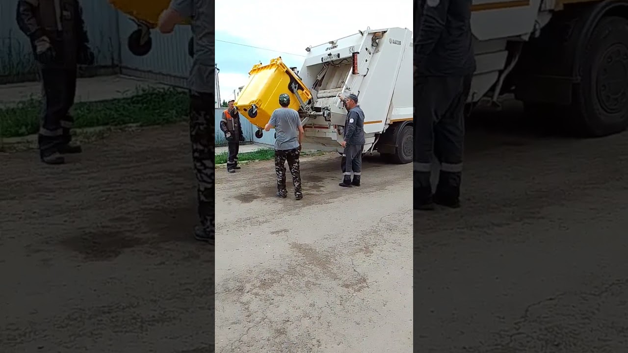 Мусоровоз КАМАЗ грузит пластиковые баки