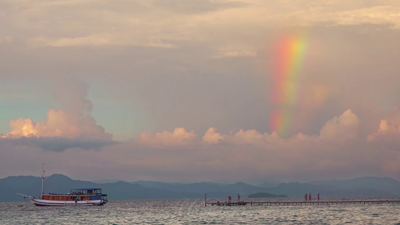 Sunset Rainbow Over a Tropical Pier