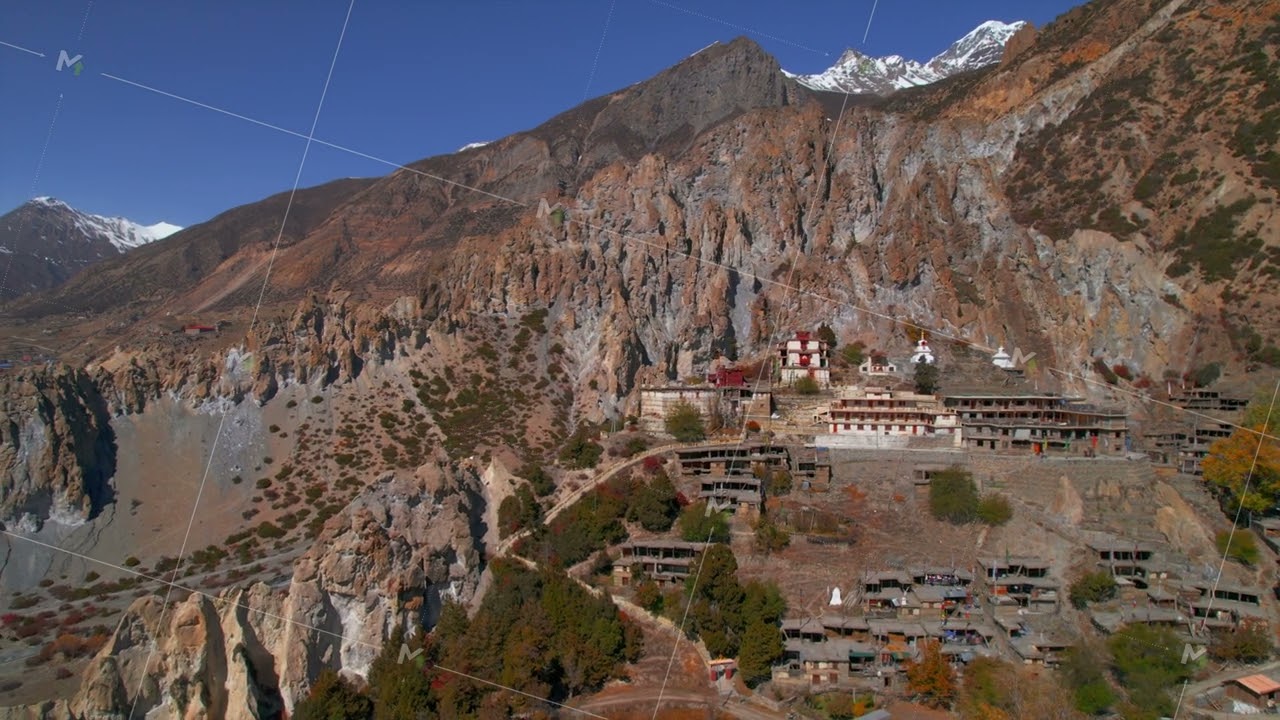 Aerial revealing view Bhraka village houses with stupa on hilltop. Manang district. Annapurna