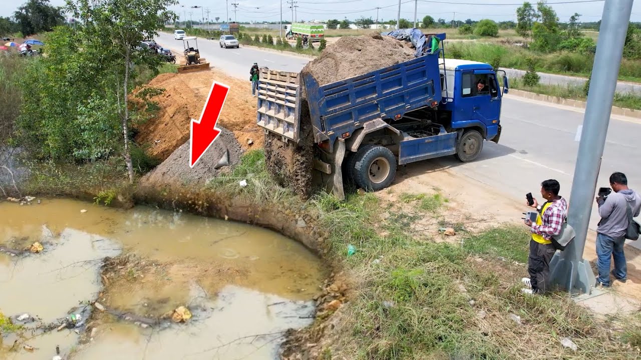 Great job dump truck unloading soil landfilling nearly road with skill operator bulldozer pushing 