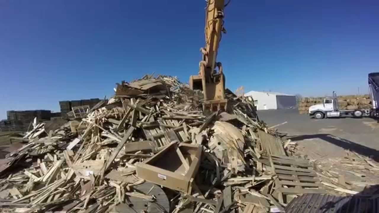 Case CX240 Excavator Loading a Peterson 4700B Horizontal Grinder