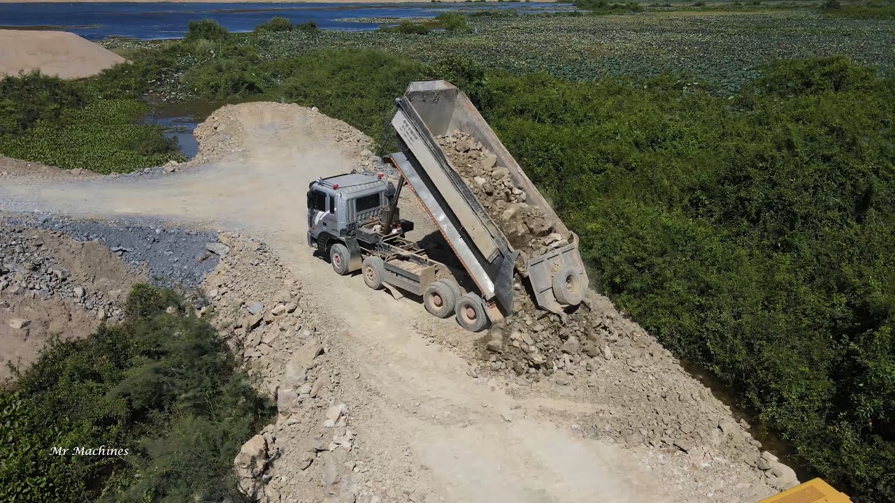 Strong Powerful Machinery Bulldozer Spreading Dirt Rock Building Road with Dump Truck Unloading