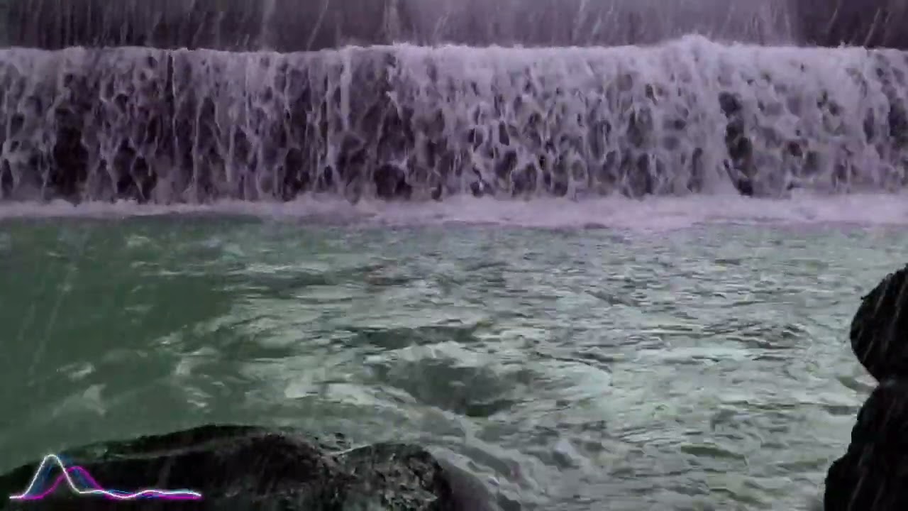 Rain Falling Over a Majestic Waterfall