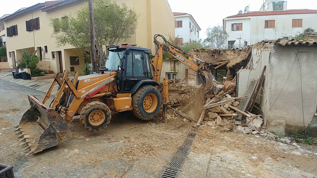 Case 590 backhoe loader demolishing old house