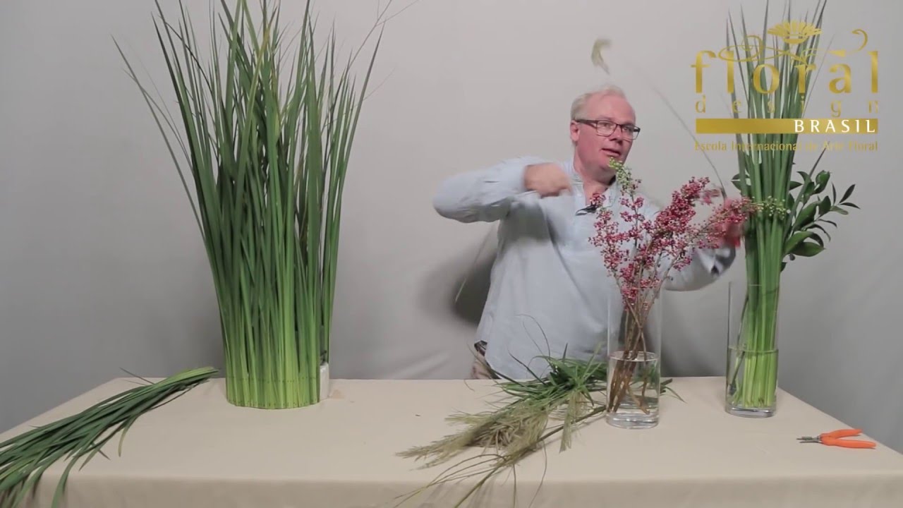 Arranjo de flores e folhagens variadas envoltas em folhas de moreia