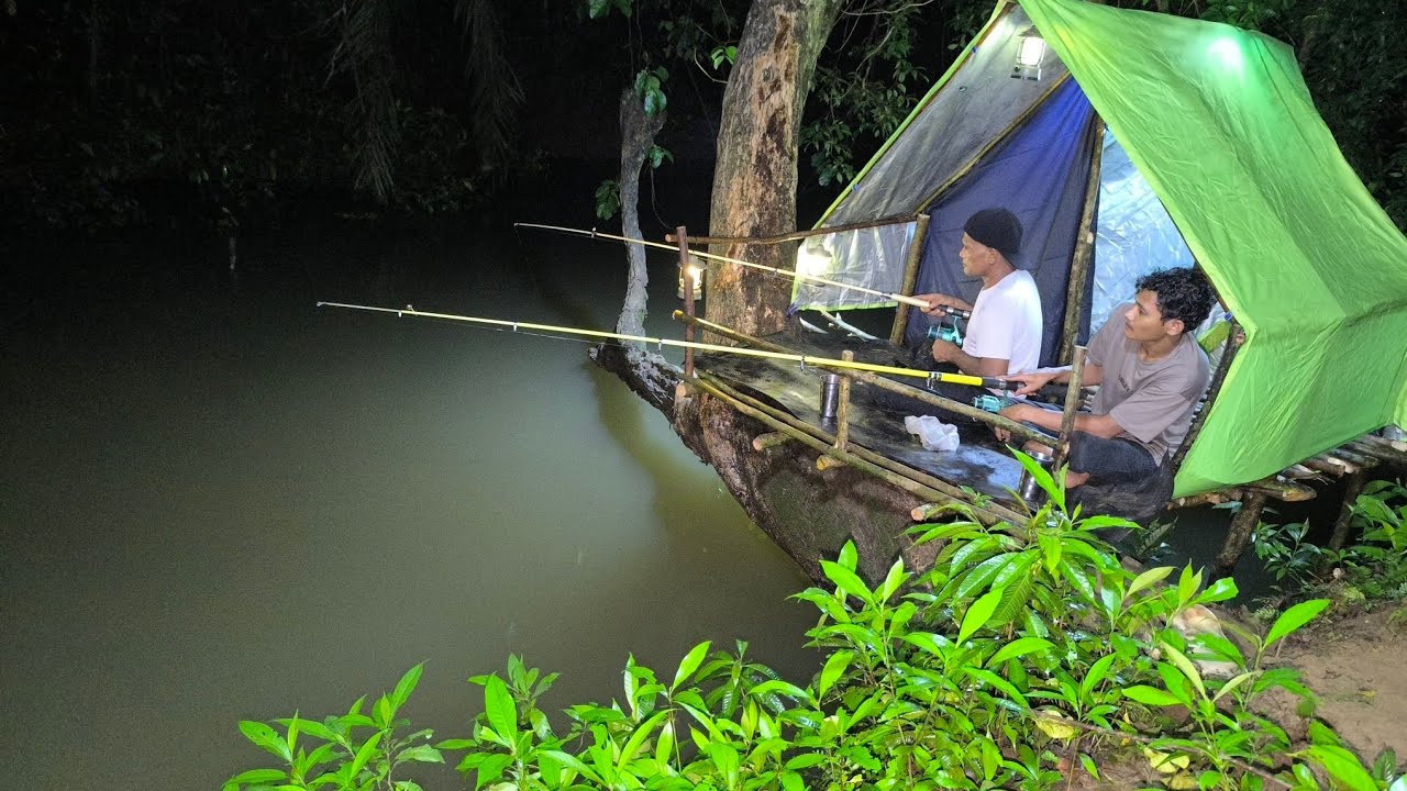 Camping hujan deras petir dan angin kencang saat air sungai banjir dan memancing ikan dari pondok 