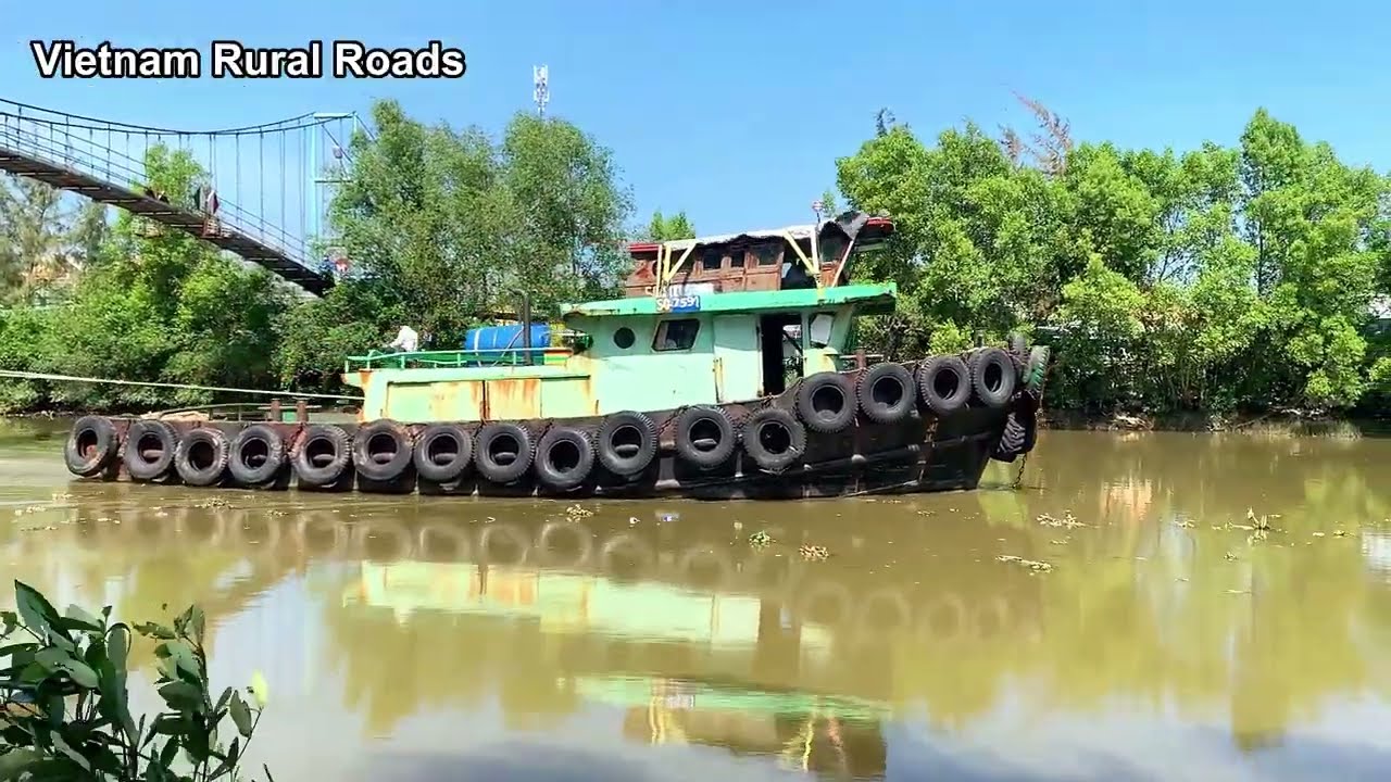 Tugboat tugs barges on river in western Vietnam