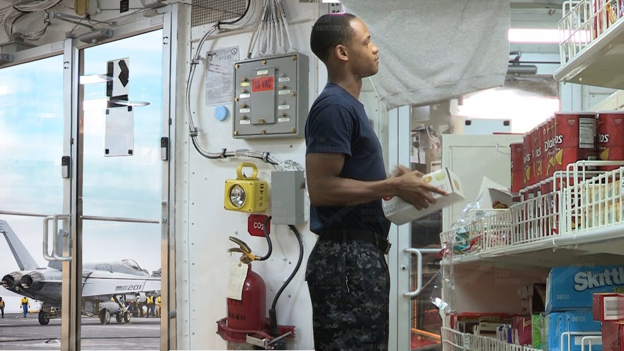 Моряки ВМС США делают покупки внутри авианосца