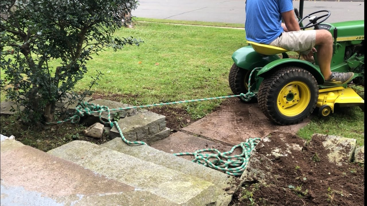 John Deere 110 pulling hedges