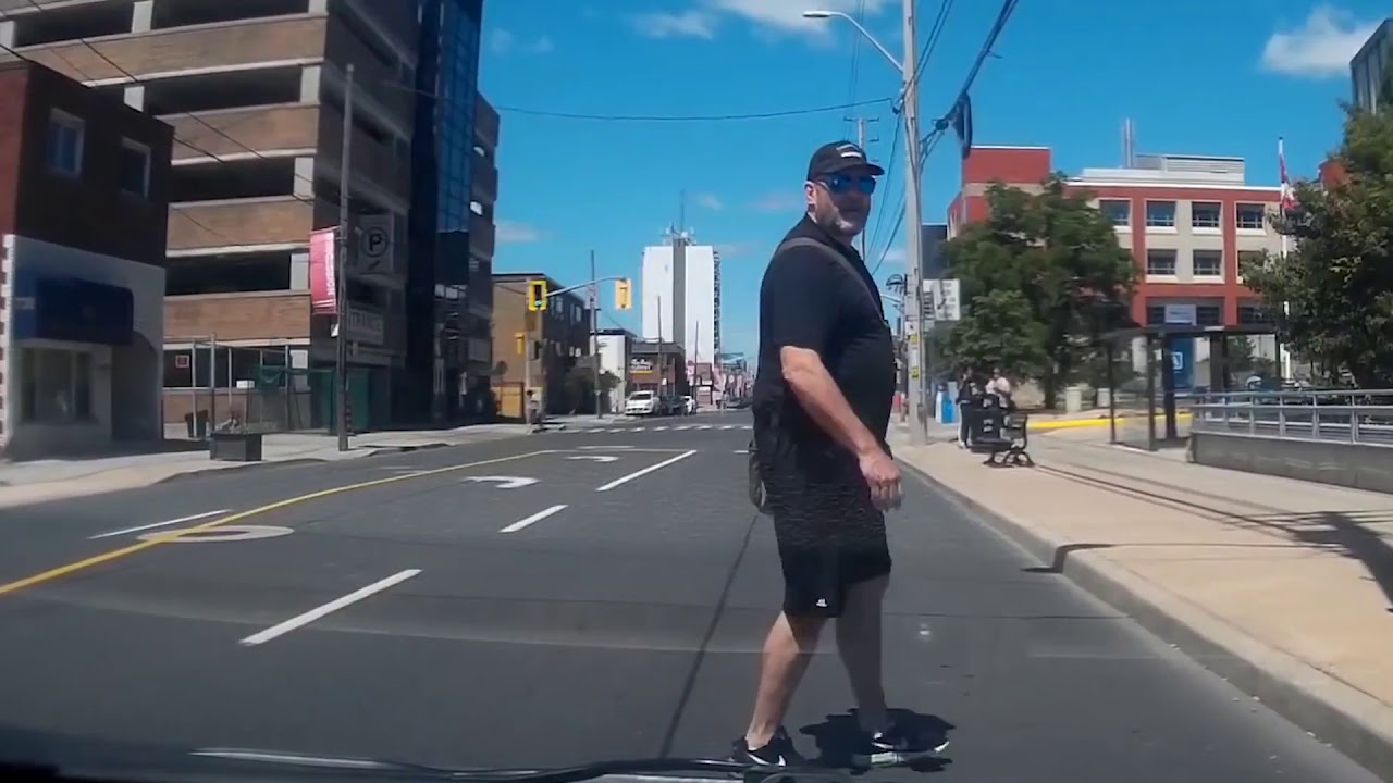 Watch Jaywalker glares at driver and runs into pole