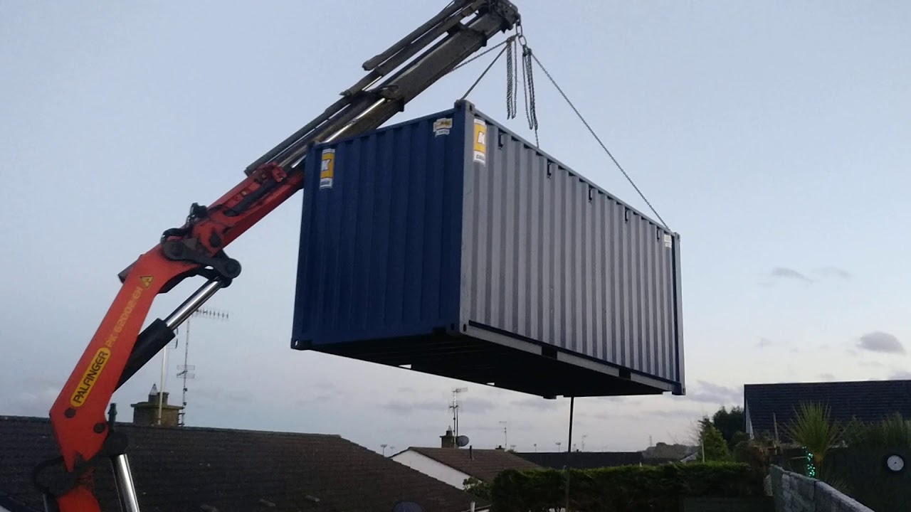 Crane operator lifts Shipping container over house!