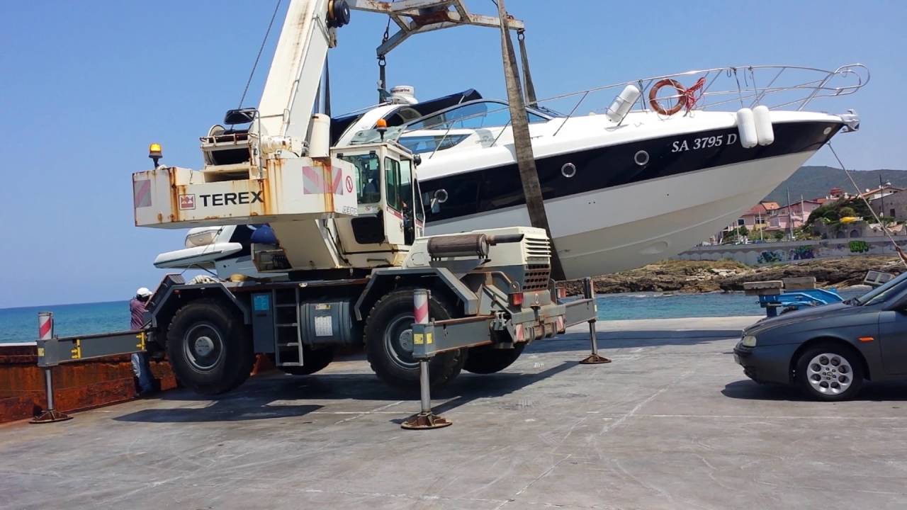 Genio con gru terex gigante come escavatore scarica barca yacht. Santa maria di castellabate