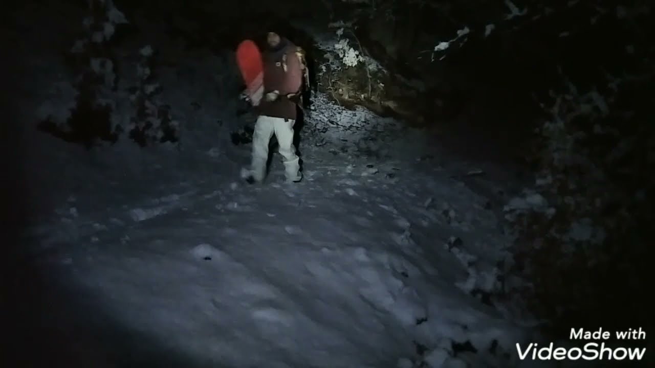 Fuori pista di notte con snowboard