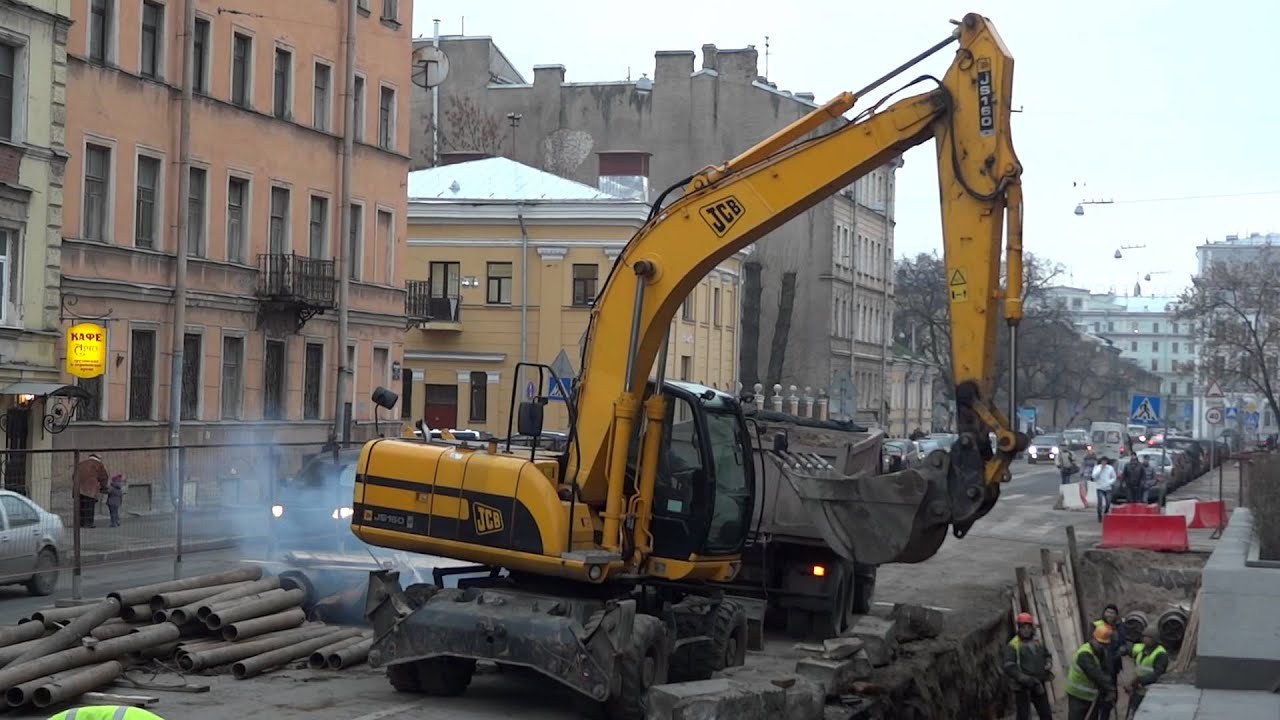 Excavator JCB JS 160 digging & CAT 424D removing rock