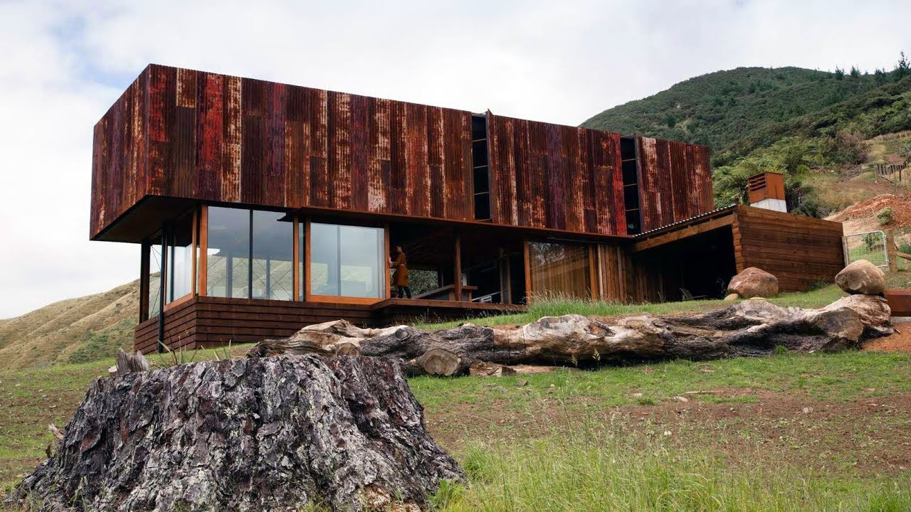 A small farmhouse by Herbst Architects with a skin of rusty recycled iron in Coromandel New Zealand.