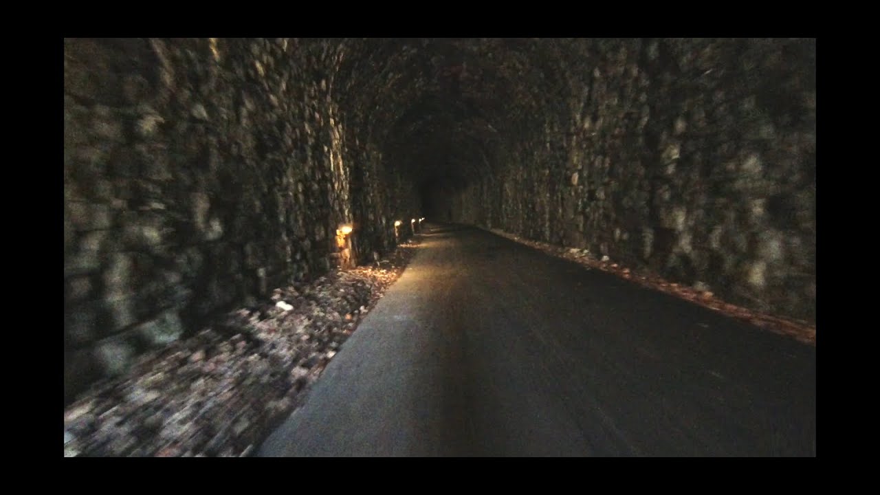 Cycling through Tidenham Tunnel, towards Chepstow on the Wye Valley Greenway