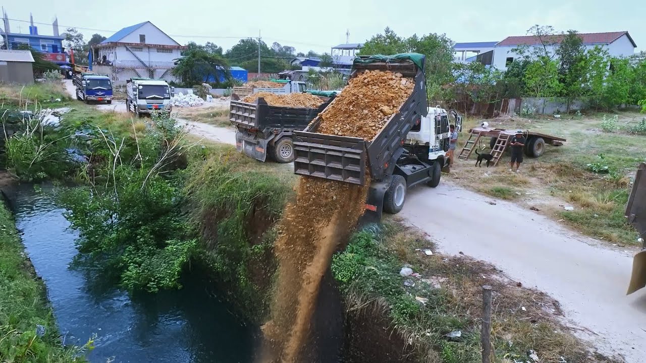 Rural Land Preparation: Dump Truck Delivering & Unloading Dirt for Embankment
