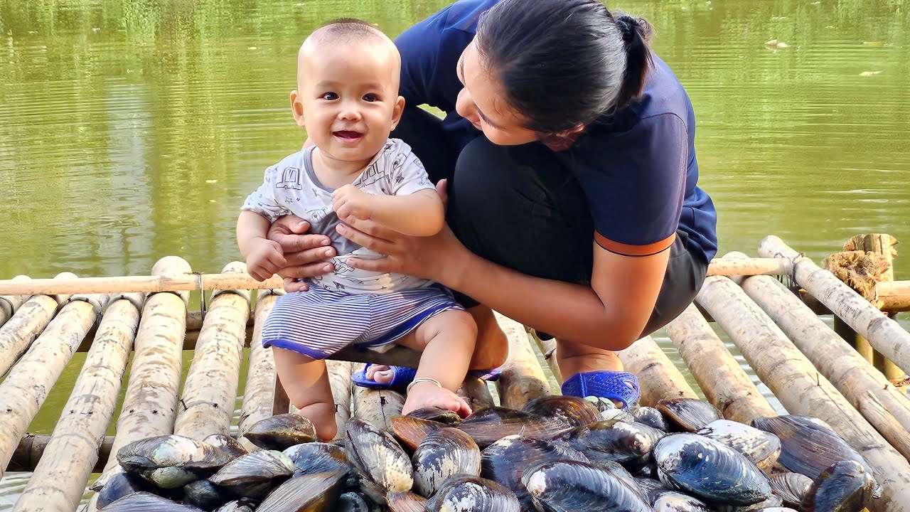 A single mother catches mollusks from a pond to sell and care for her young child - Le Thi Hon