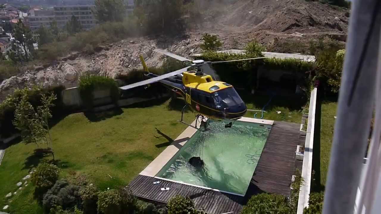 Amazing helicopter pilot taking water from swimming pool