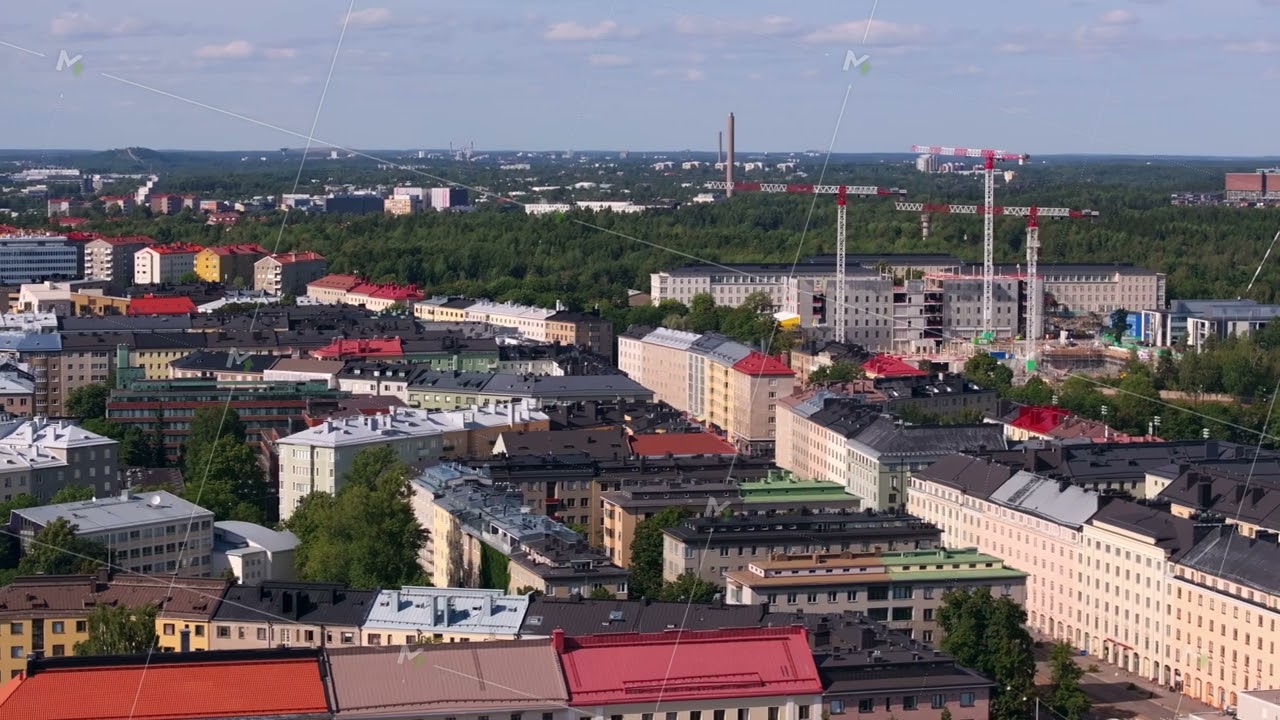 Aerial view of Helsinki, Finland showcasing the cityscape with construction cranes in the distance