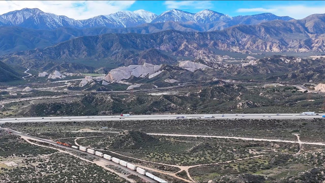 A dual engine BNSF intermodal passes Hill 582 with a spectacular view of Mormon Rocks near the end.
