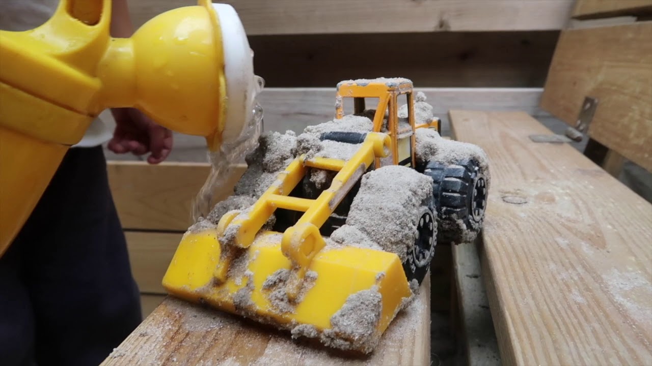 Met speelgoed in de zandbak spelen