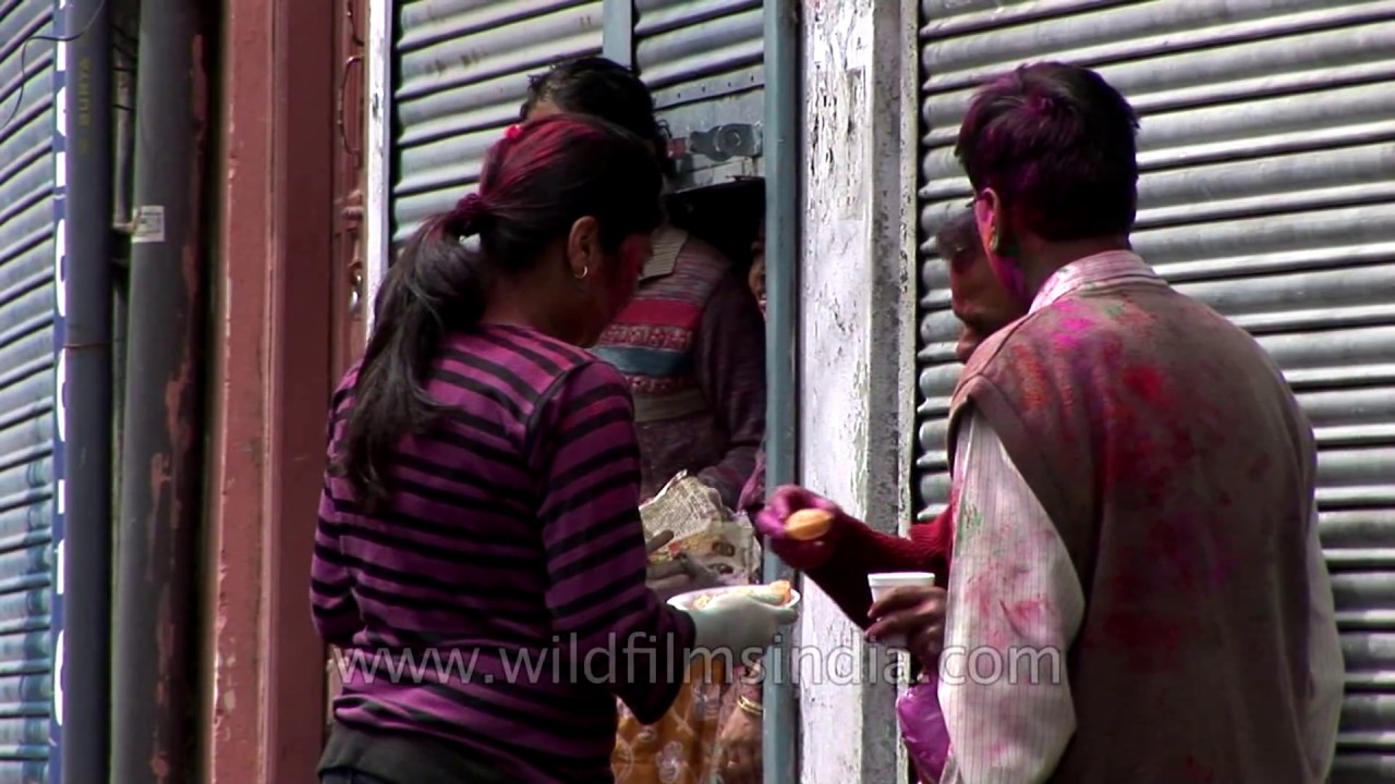 Girl offers snacks during Holi celebrations