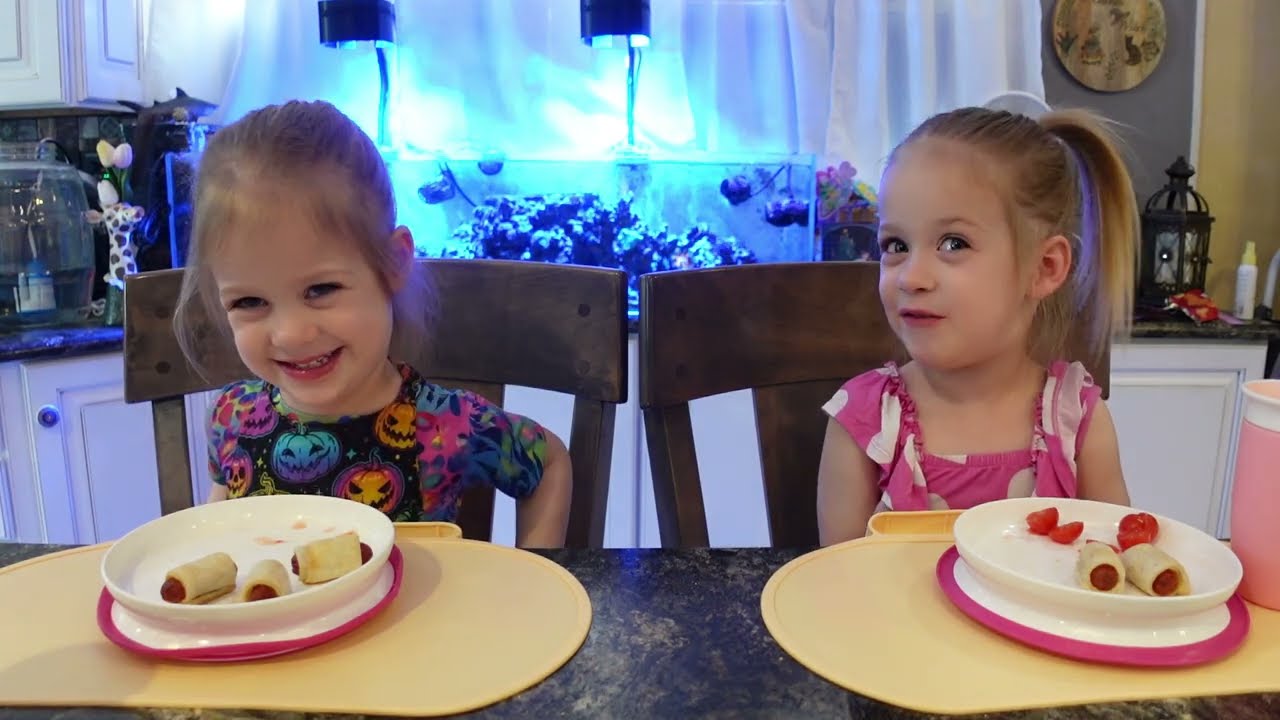 Twins try pigs in a blanket