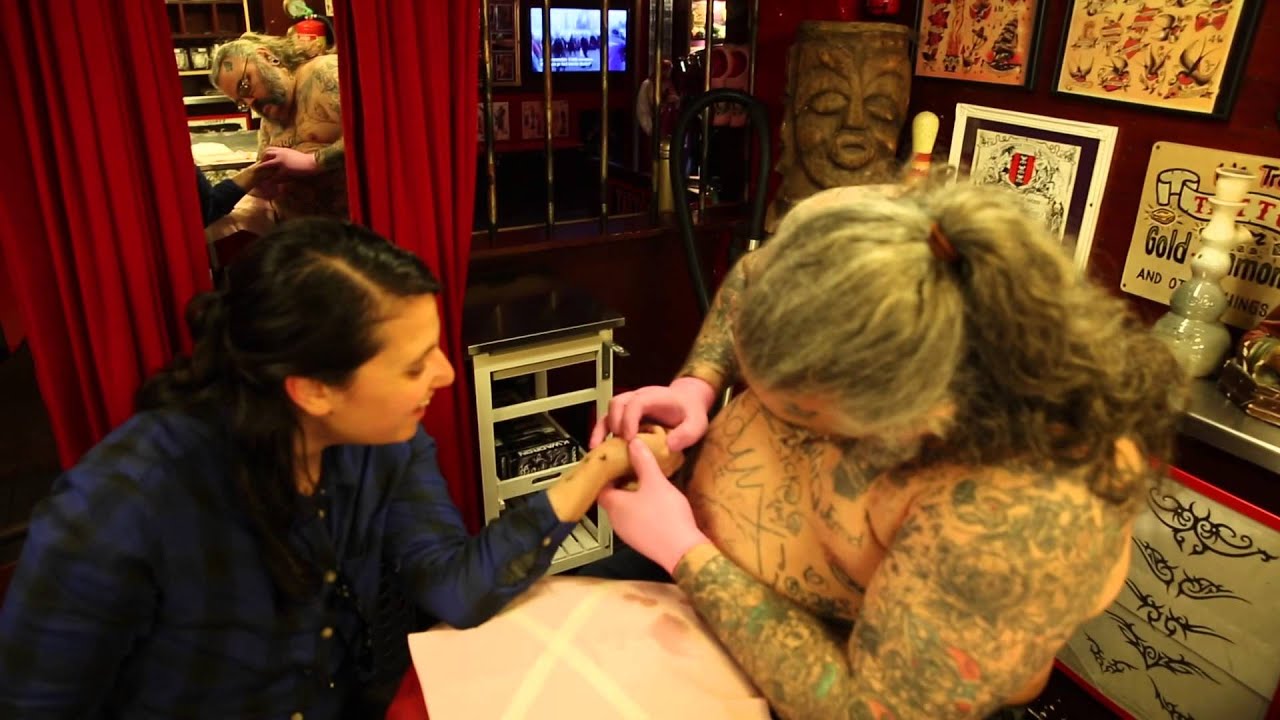 Dikke Dennis aan het werk in de tattooshop