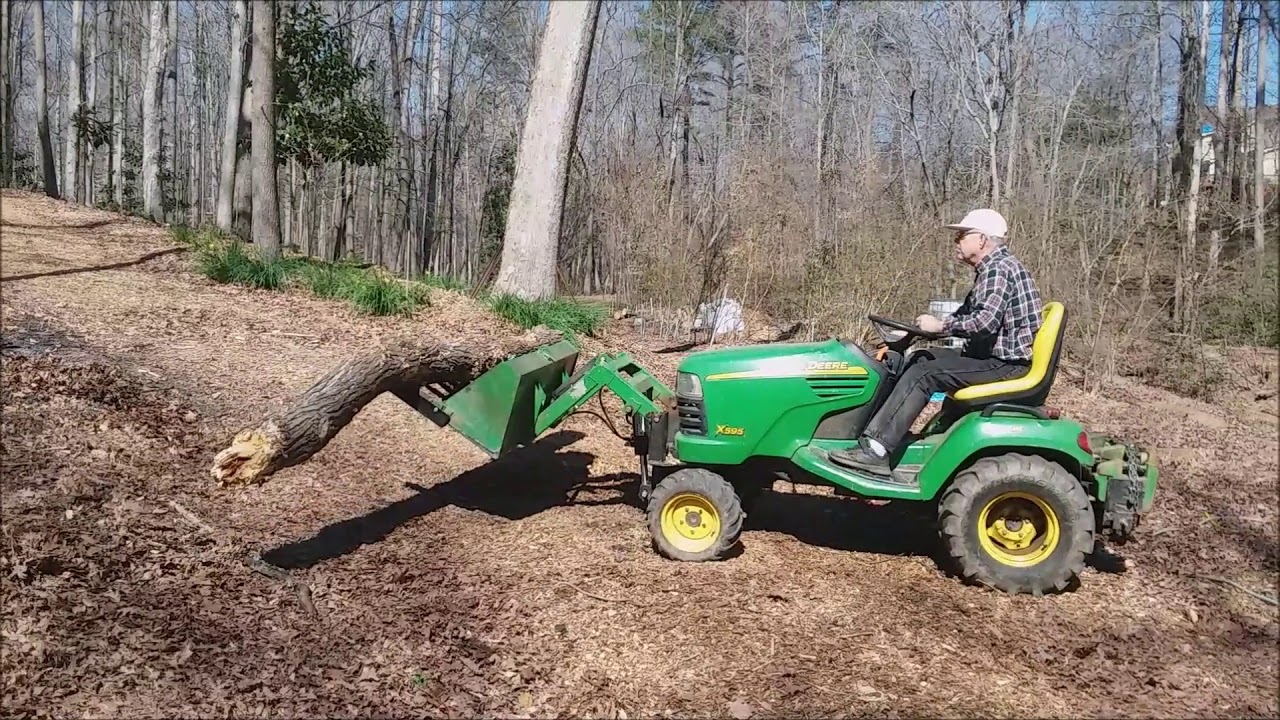 Buford Bucket Loader on JD X Series Tractor Moving Logs
