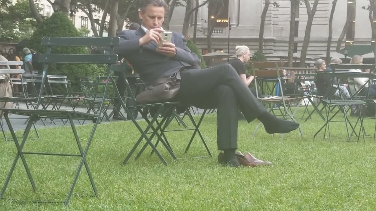 White Businessman Airs Out Dress Sock In Park