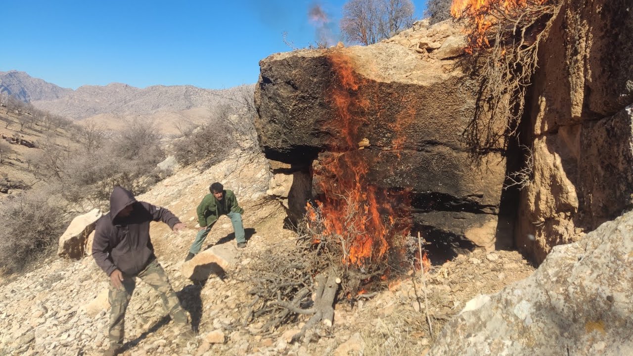Winter survival shelter. Using fire under a rock 