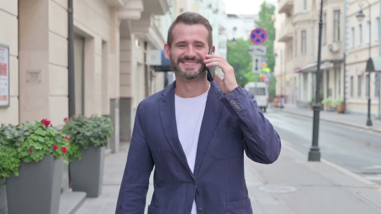 man talking on phone while walking down the street 2022 08 10 11 23 03 utc