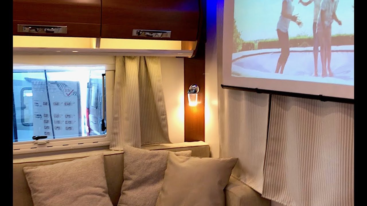 Rapido 8094 med en lounge sofagruppe bak