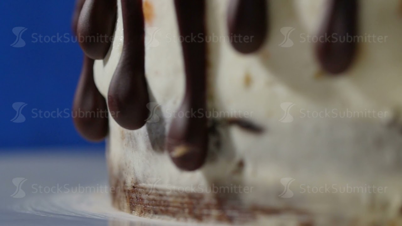 Close-up part of the chocolate Cake with the white lines and frozen drops - food background
