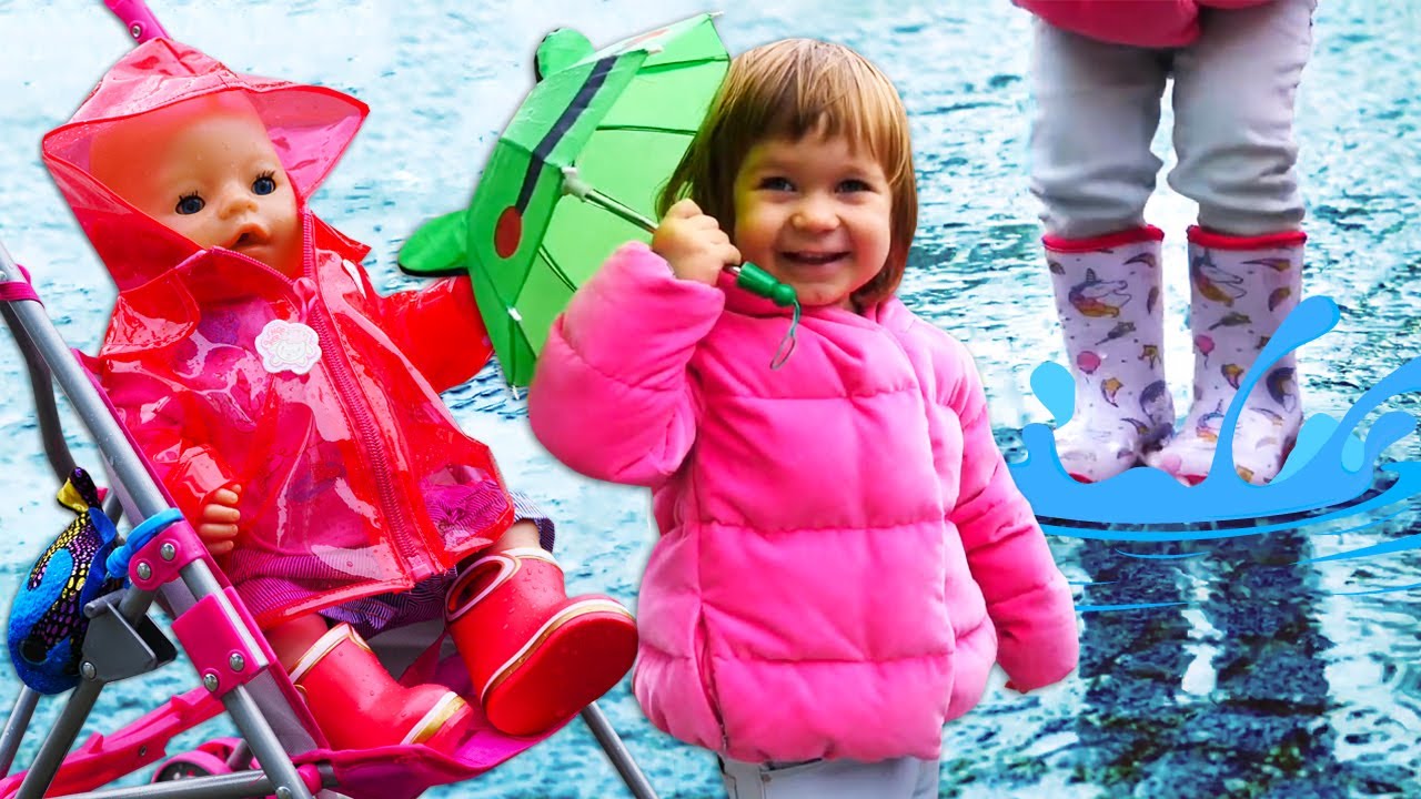 Bianca brincando em po&ccedil;as de &aacute;gua em um dia chuvoso. Capa de chuva para boneca. V&iacute;deo infantil.