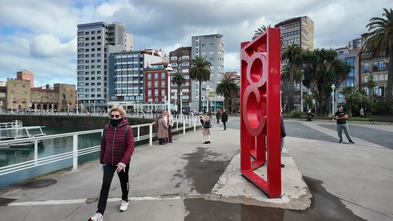 Walking along Gij&oacute;n waterfront promenade from marina to San Lorenzo beach, Asturias, Spain