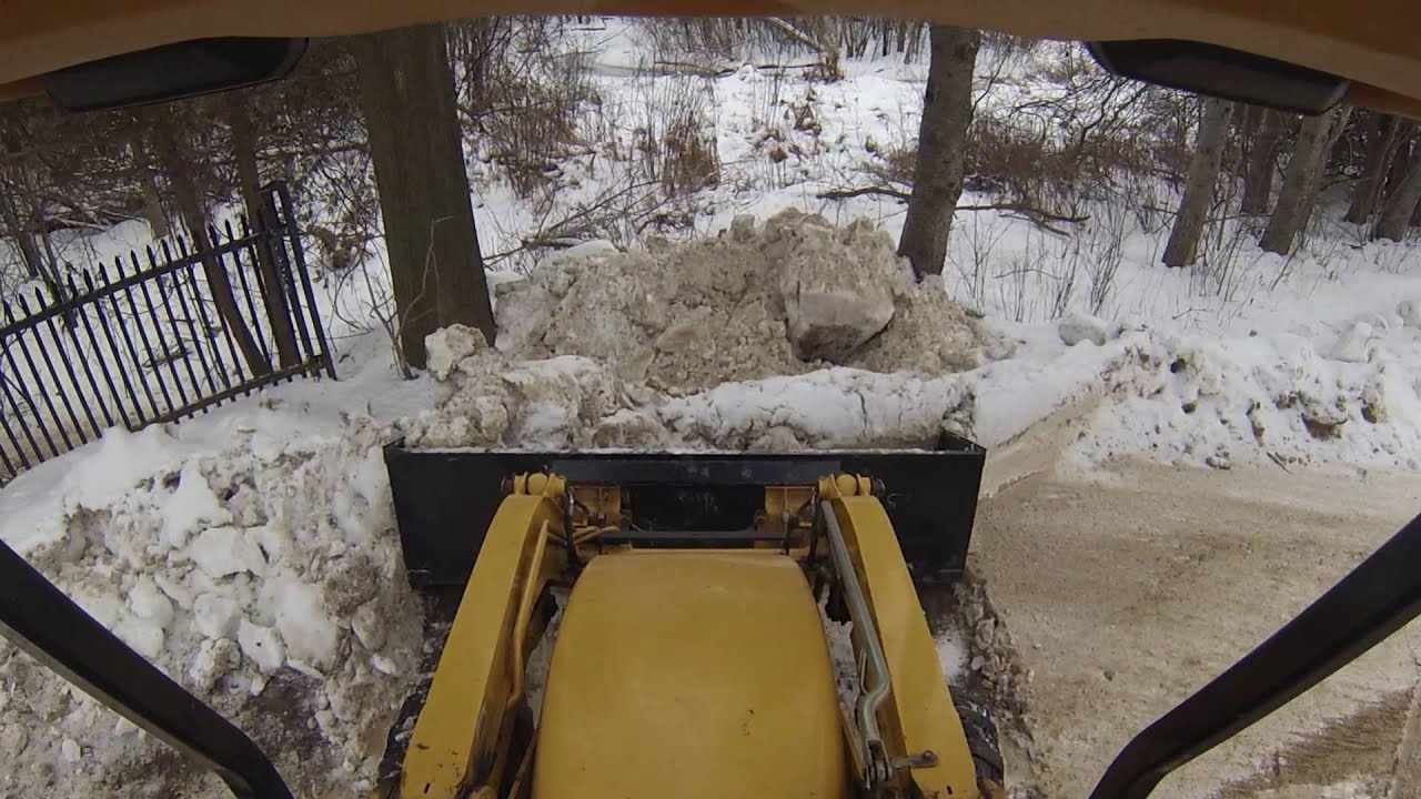 clearing snow with the huge loader bucket and stirring leaves